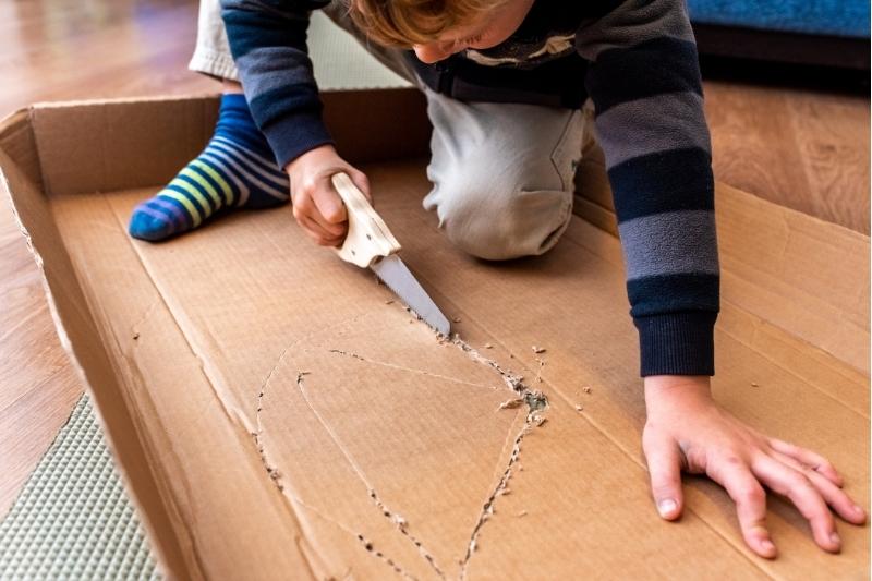 Homeschooling in Real Life: Boy Cutting Cardboard